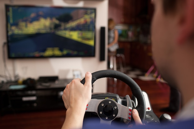 Homem jogando jogo de corrida com simulador de volante