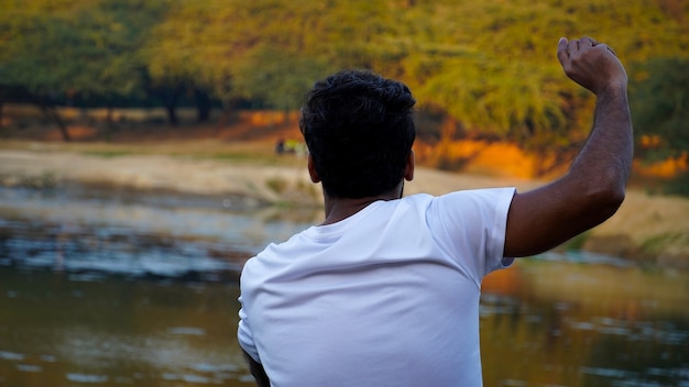 Homem jogando pedras no lago. Conceito de jovem homem asiático isolado