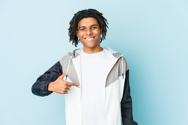 Homem jovem afro-americano apontando com a mão para um espaço de cópia de camisa, orgulhoso e confiante