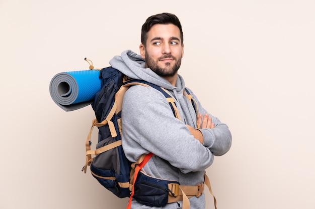 Homem jovem alpinista com uma mochila grande rindo