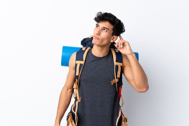 Foto homem jovem alpinista com uma mochila grande sobre parede isolada