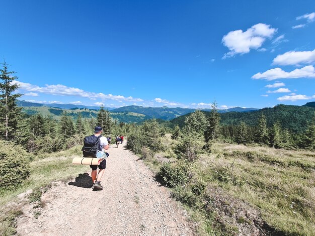 Homem jovem alpinista nas montanhas. trilha de caminhada de verão. copie o espaço.