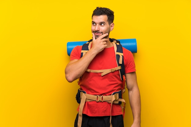 Homem jovem alpinista pensando uma idéia