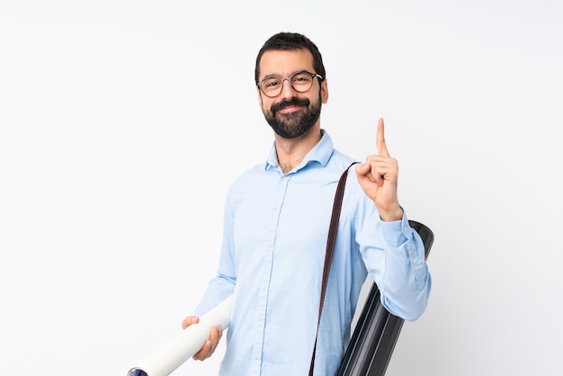 Homem jovem arquiteto com barba sobre fundo branco isolado, mostrando e levantando um dedo em sinal dos melhores