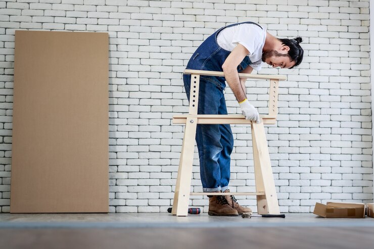 Foto homem jovem asiático moderno trabalhando como faz-tudo, montando mesa de madeira com equipamentos.