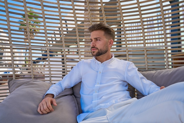 homem jovem barba relaxado em um guarda-sol de praia