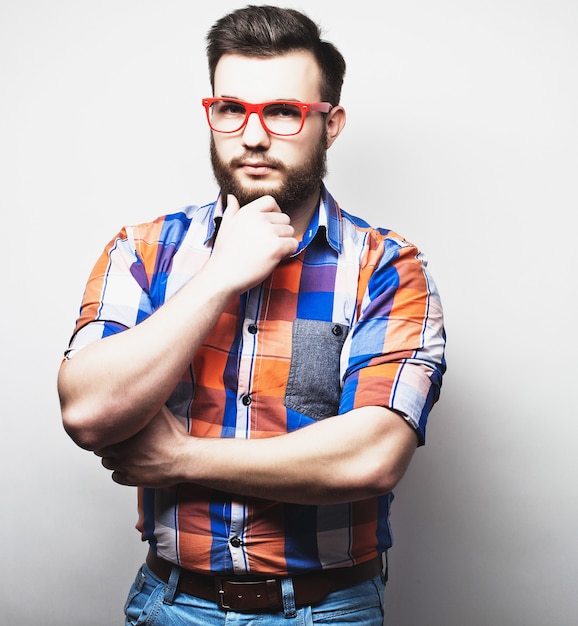 Homem jovem barbudo hippie com óculos vermelhos