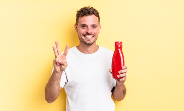 Homem jovem bonito sorrindo e parecendo amigável, mostrando o número três. conceito de ketchup