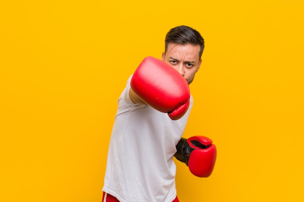 Homem jovem boxeador sul-asiático usando luvas vermelhas.