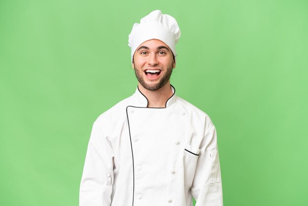 Homem jovem chef bonito sobre fundo isolado com expressão facial de surpresa