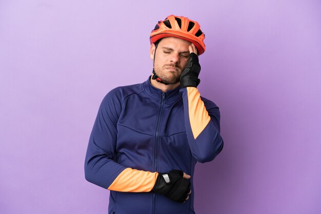 Homem jovem ciclista brasileiro isolado em fundo roxo com dor de cabeça