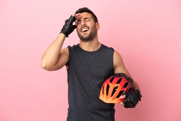 Homem jovem ciclista isolado em fundo rosa sorrindo muito