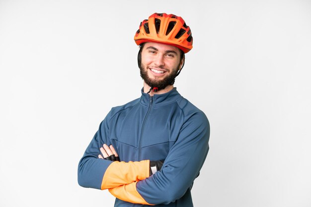 Foto homem jovem ciclista sobre fundo branco isolado com os braços cruzados e olhando para a frente