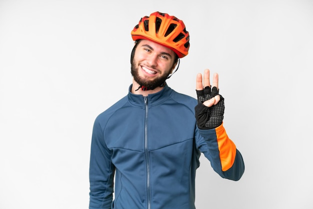 Homem jovem ciclista sobre fundo branco isolado feliz e contando três com os dedos