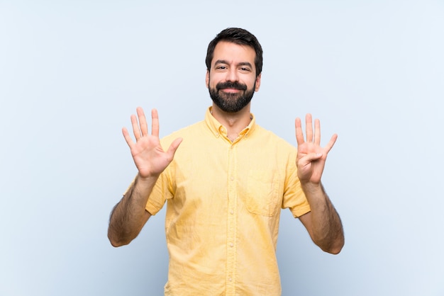 Homem jovem, com, barba, ligado, azul, contando nove, com, dedos