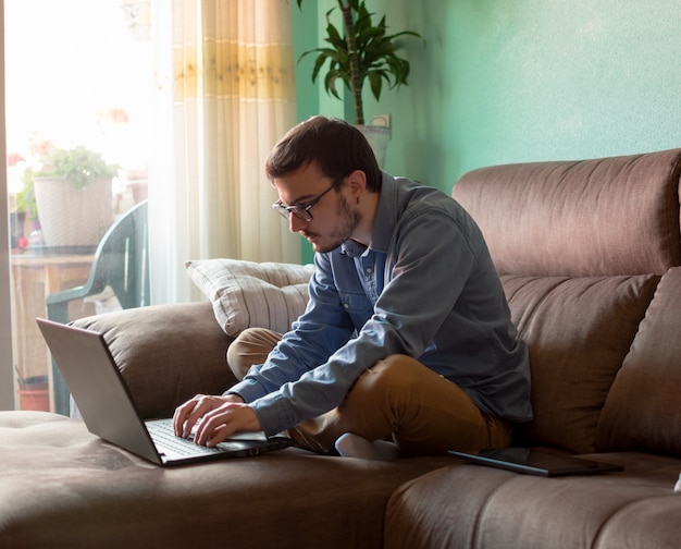 Foto homem jovem, com, laptop, ligado, sofá, casa