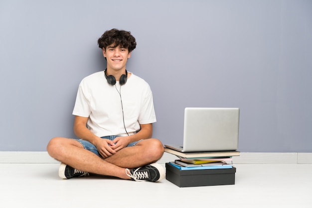 Homem jovem, com, seu, laptop, sentando um, a, chão, rir