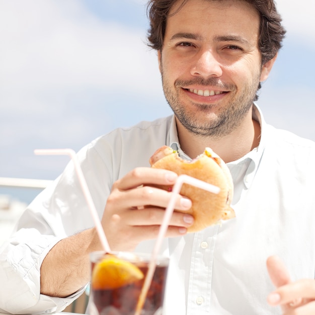 Homem jovem, comer, um, hamburguer