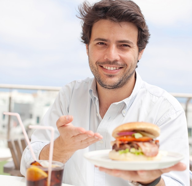 Homem jovem, comer, um, hamburguer