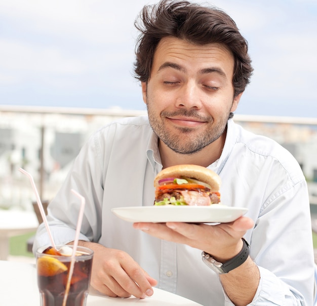 Homem jovem, comer, um, hamburguer