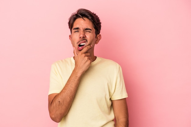 Homem jovem de raça mista, isolado no fundo branco, tendo uma forte dor nos dentes, dor molar.