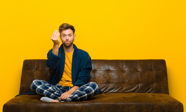 Homem jovem, desgastar, pijama, fazendo dinheiro, gesto