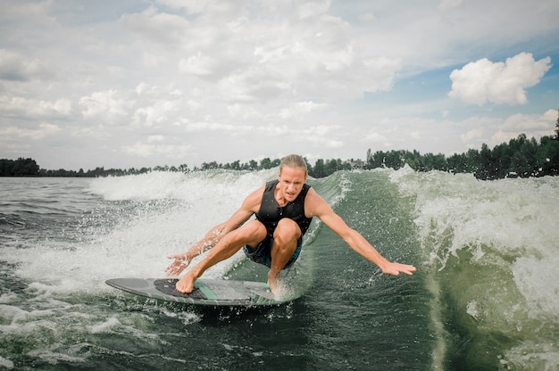 Homem jovem e atlético, wakesurf no quadro rio abaixo