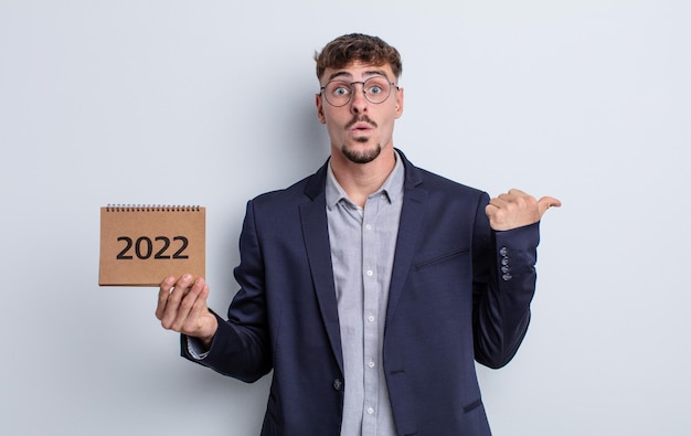 Homem jovem e bonito parecendo espantado com a descrença. conceito de calendário