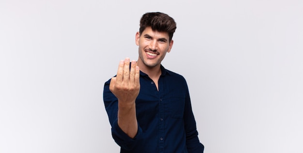 Homem jovem e bonito sentindo-se feliz, bem-sucedido e confiante, enfrentando um desafio e dizendo "Vamos lá!" ou dando boas-vindas a você