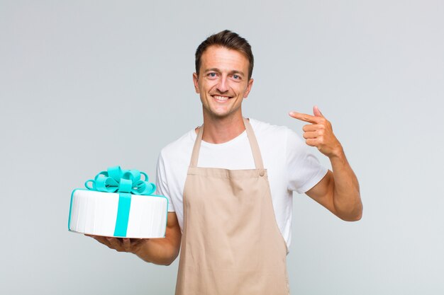 Homem jovem e bonito sorrindo com confiança apontando para o próprio sorriso largo, atitude positiva, relaxada e satisfeita