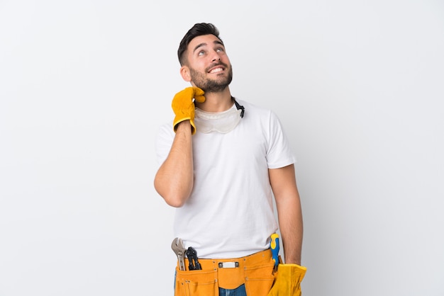 Homem jovem eletricista sobre parede isolada