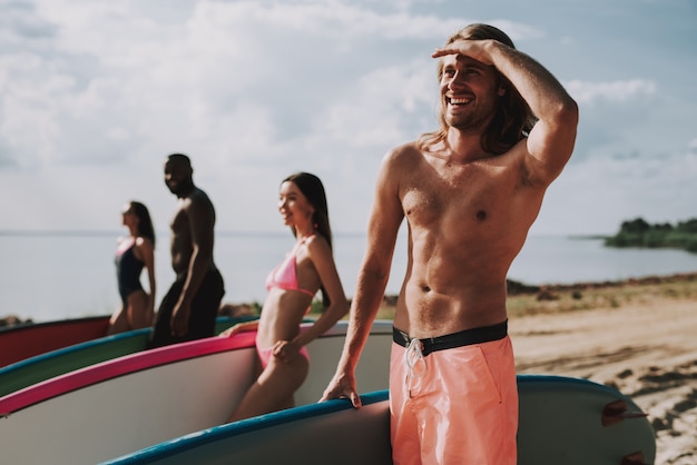 Homem jovem, em, swimsuits, levantando praia