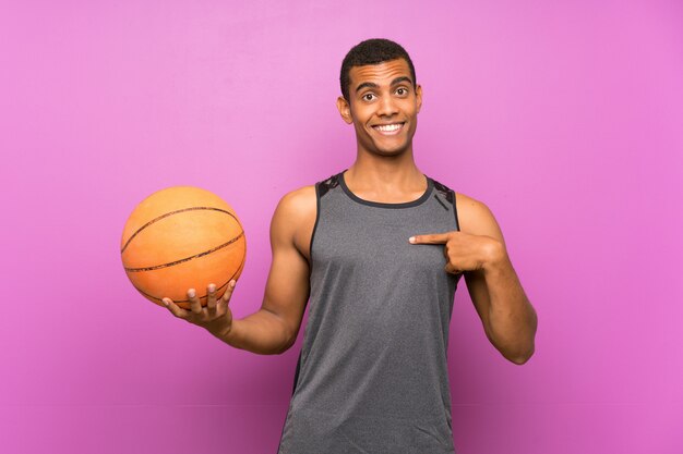 Homem jovem esporte com bola de basquete com expressão facial de surpresa