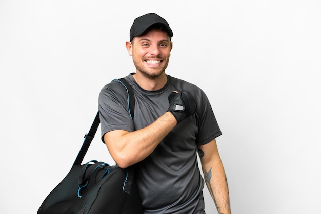 Homem jovem esporte com bolsa esportiva sobre fundo branco isolado comemorando uma vitória