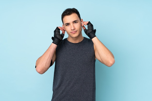 Homem jovem esporte isolado sobre música de parede azul