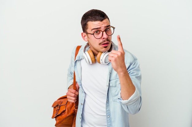 Homem jovem estudante caucasiano ouvindo música isolada no fundo branco, tendo uma ideia, o conceito de inspiração.