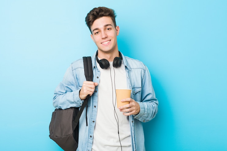 Foto homem jovem estudante caucasiano segurando um café para viagem feliz, sorridente e alegre.