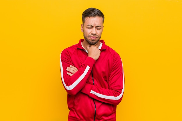 Homem jovem fitness filipino sofre dor na garganta devido a um vírus ou infecção.