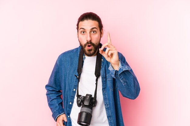 Homem jovem fotógrafo caucasiano isolado tendo uma ideia, o conceito de inspiração.