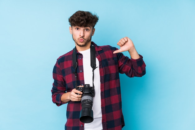 Homem jovem fotógrafo isolado sente-se orgulhoso e auto-confiante, exemplo a seguir