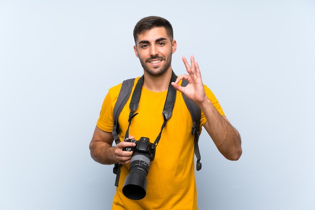 Homem jovem fotógrafo mostrando um sinal de ok com os dedos