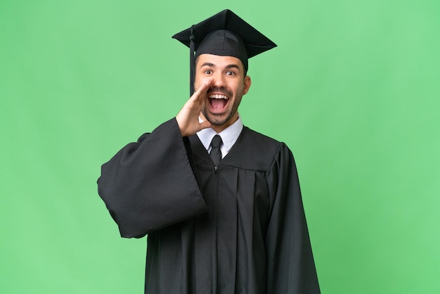 Homem jovem graduado da universidade sobre fundo isolado com surpresa e expressão facial chocada