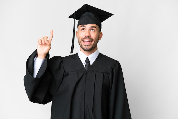 Homem jovem graduado universitário sobre fundo branco isolado, com a intenção de perceber a solução enquanto levanta um dedo