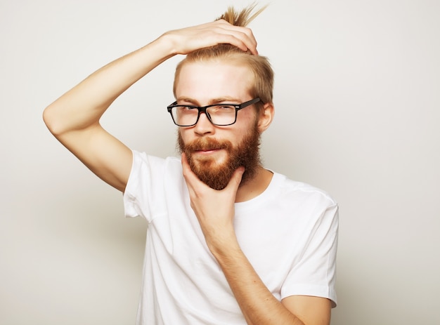 Homem jovem hippie barbudo usando óculos de fundo branco.