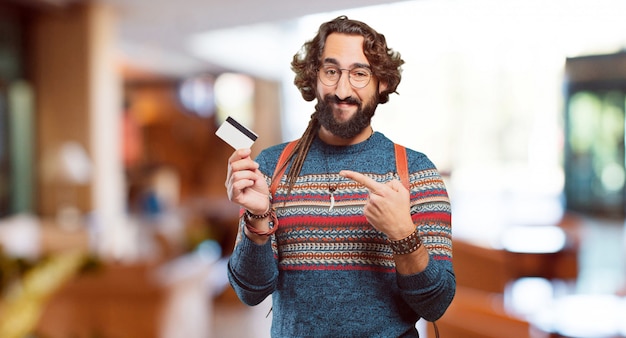 Homem jovem hippie com um cartão de crédito