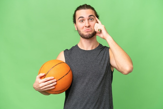 Homem jovem jogador de basquete sobre fundo isolado, pensando em uma idéia