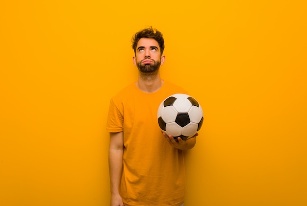 Homem jovem jogador de futebol cansado e entediado