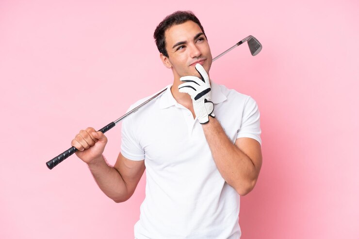 Foto homem jovem jogador de golfe isolado no fundo rosa com dúvidas enquanto olha para cima