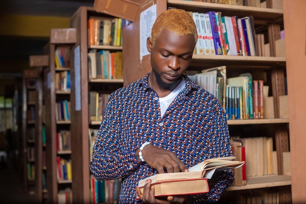 Homem jovem, leitura, livro, em, biblioteca