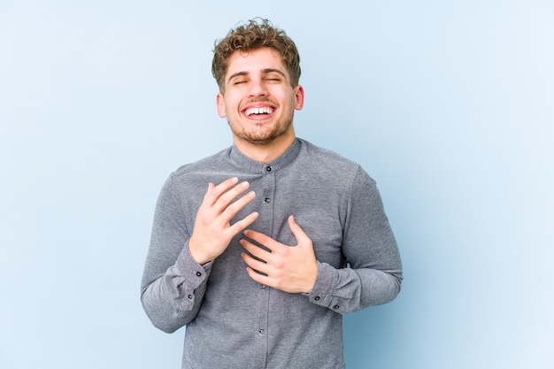 Homem jovem loiro encaracolado caucasiano isolado alegre rindo muito. Conceito de felicidade.